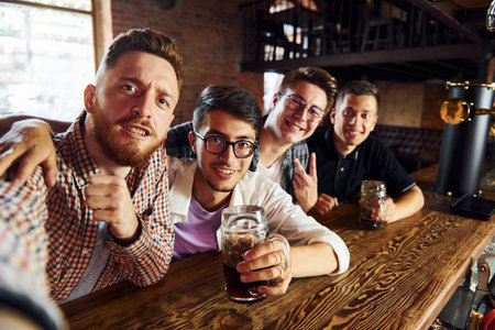 Making selfie. People in casual clothes sitting in the pubの写真素材