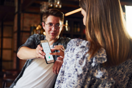 Young man with woman. People in casual clothes sitting in the pubの写真素材