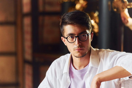 Young man in casual clothes sitting in the pubの写真素材