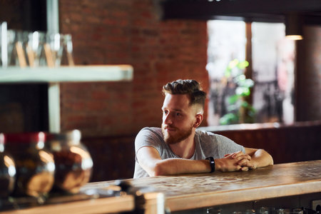 Young man in casual clothes sitting in the pubの写真素材