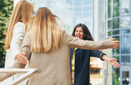 Good friends. Women in formal wear is outdoors in the city togetherの写真素材