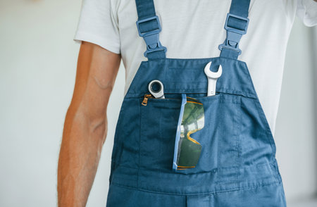 With equipment. Young man working in uniform at construction at daytimeの写真素材