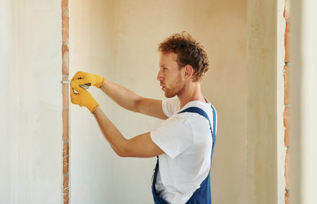 Modern technologies. Young man working in uniform at construction at daytimeの写真素材
