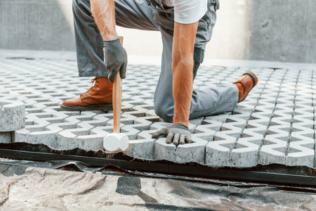 Sitting outdoors. Young man working in uniform at construction at daytimeの写真素材