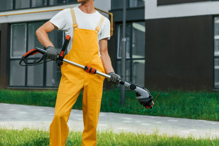 Outdoors in the yard. Man cut the grass with lawn moverの写真素材