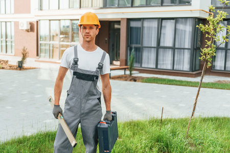 Ready for work. Young man in uniform at construction at daytimeの写真素材