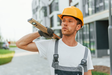 Walking outdoors. Young man working in uniform at construction at daytimeの写真素材