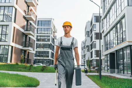 Finished buildings. Young man working in uniform at construction at daytimeの写真素材