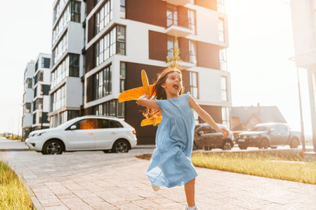 Cheerful little girl walking outdoors in the city in dressの写真素材