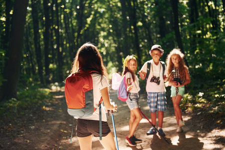 Ready for adventure. Kids strolling in the forest with travel equipmentの写真素材