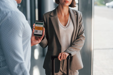 Modern technologies. Woman showing her vaccine passport by using smartphone to the manの写真素材