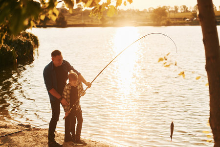 With catch. Father and son on fishing together outdoors at summertimeの写真素材