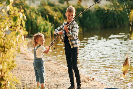Having fun. Boy with his sister in on fishion outdoors at summertime togetherの写真素材