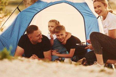 Conception of vacation. Family of mother, father and kids is on the campingの写真素材