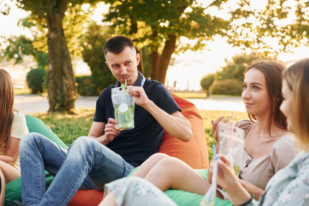 Beautiful sunlight. Group of young people have a party in the park at summer daytimeの写真素材