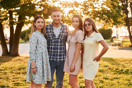 Man with three women standing in the park and embracingの写真素材