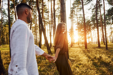 Non urban scene. Happy couple is outdoors in the forest at daytimeの写真素材