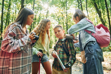 Standing together. Kids in green forest at summer daytime togetherの写真素材