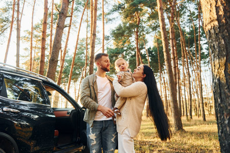 Joy and happiness. Family of father, mother and little daughter is in the forestの写真素材