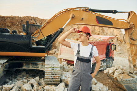 Portrait of worker in professional uniform that is on the borrow pit at daytimeの写真素材