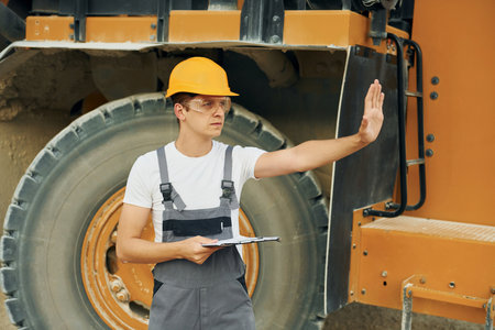 Manager planning the work. Man in professional uniform is on the borrow pit at daytimeの写真素材