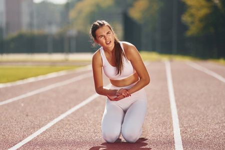 Front view. Young woman in sportive clothes is exercising outdoorsの写真素材