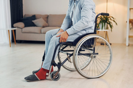 Trying to move. Disabled man in wheelchair is at home.