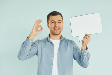 Smiling and having a good mood. Man standing in the studio with empty signs for the text.