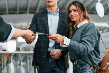 Giving the documents. Young couple is in the airport together.の写真素材