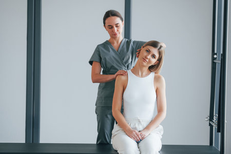 Neck exercises. Woman is in health center getting help by doctor.の写真素材