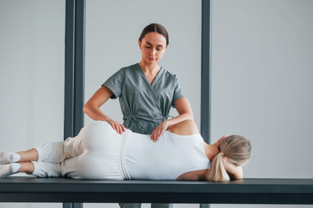 Massaging the back. Woman is in health center getting help by doctor.の写真素材