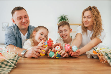 Father, mother, son and daugher. Happy family celebrating Easter holidays together.