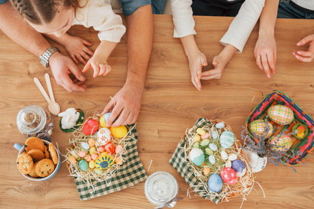 Top view of hands on the table. Happy family celebrating Easter holidays together.