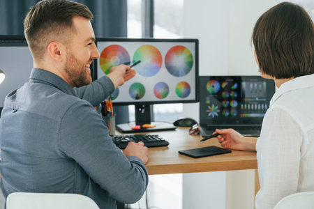 Talking with each other about new ideas. Two designers working together in the office.
