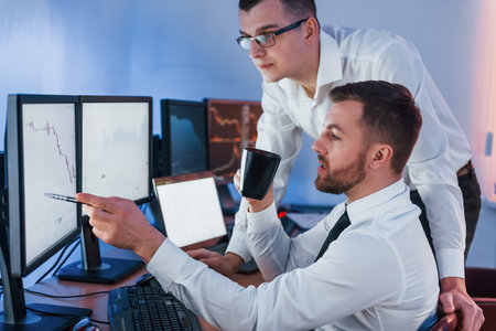 Professional occupation. Two stock traders working in the office with exchange technology.