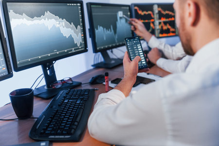 Money investment. Two stock traders working in the office with exchange technology.