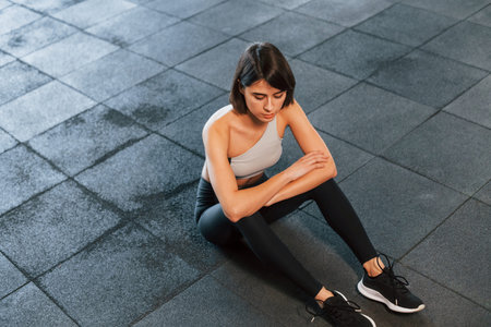 Top view. Woman in sportive clothes with slim body type is in the gym.