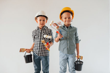 Friends together indoors. Two boys painting walls in the domestic room.の写真素材