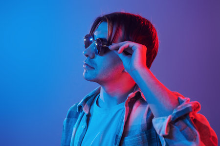 Stylish look. Man standing in the studio with neon light.
