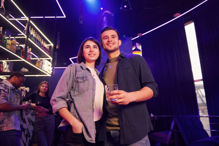 Man with his girlfriend. Group of friends having fun in the night club together.