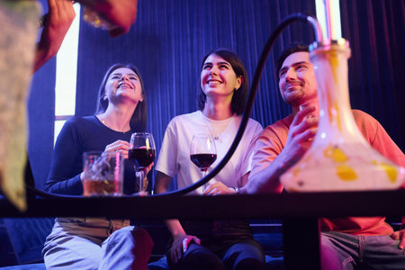 Talking with each other. Group of friends having fun in the night club together.