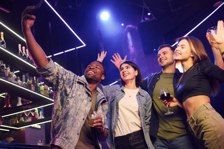 Making photo. Group of friends having fun in the night club together.