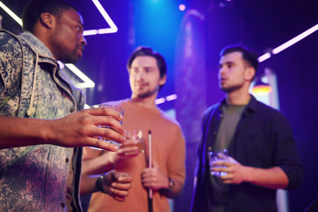 Blue lighting interior. Group of friends having fun in the night club together.