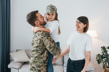 Soldier in uniform is at home with his wife and daughter.の写真素材