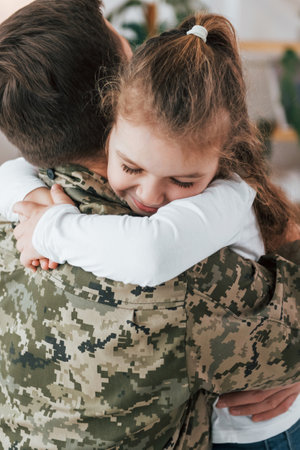 Finally meet each other. Soldier in uniform is at home with his little daughter.の写真素材