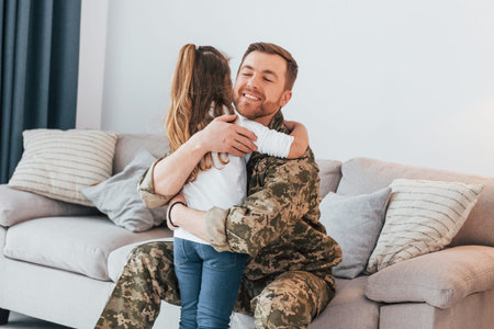 Finally at home. Soldier in uniform is with his little daughter.