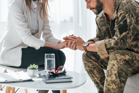 Post traumatic stress disorder. Soldier have therapy session with psychologist indoors.の写真素材