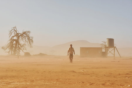 In the dead city. Male tourist in casual clothes is in the deserts of Africa, Namibia.