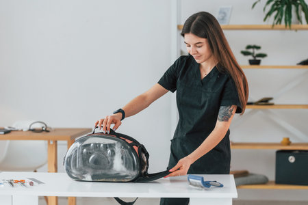 In the pet carrier. Cute little rabbit is in the grooming studio.の写真素材