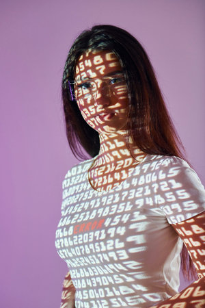 Different digits. Beautiful young woman is in projector neon lights in the studio.